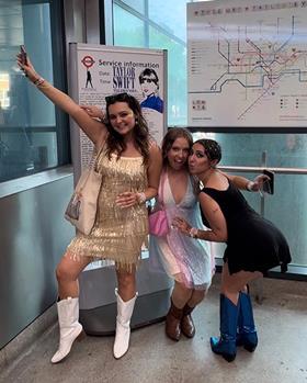 Fans attending Taylor Swift's The Eras Tour pose in front of TfL's Swift-themed Tube map at Wembley Park station (Photo TfL)