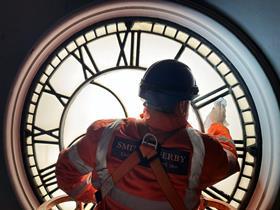 Close up of Dan Noble from Smiths of Derby cleaning exterior of clock face (Photo Network Rail)