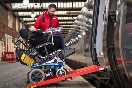 Train passenger using a wheelchair ramp