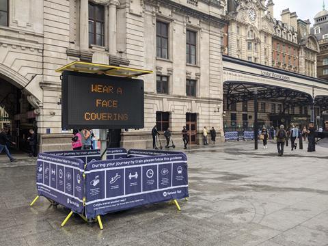 gb London Victoria coronavirus social distancing electric face covering sign