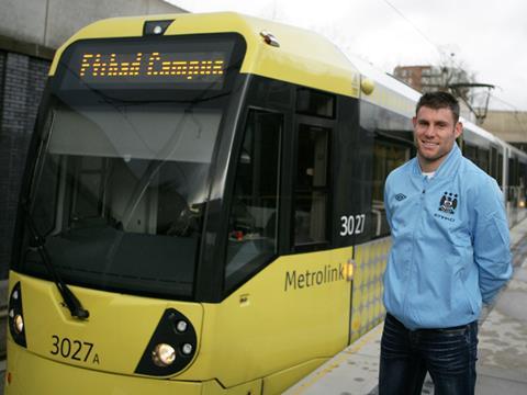 Manchester City FC player James Milner with Metrolink light rail vehicle.