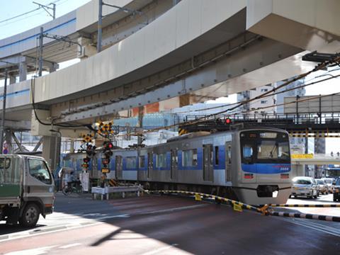 The level crossing carried the 1 435 mm gauge Keihin Kyuko Railway across the busy main road, until being replaced by the viaduct above.