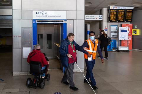 Transport for London staff assist a blind passenger