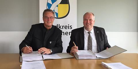 Garching Mayor Dr Dietmar Gruchmann and District Administrator Christoph Göbel sign the purchase agreement (Photo Landkries Muenchen)