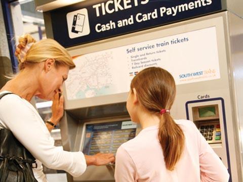 Passengers using a ticket machine.